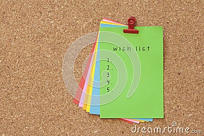 Wish List written on color sticker notes over cork board background Stock Photo