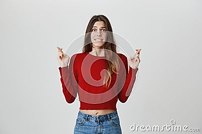 Wish me luck. Isolated portrait of young beautiful female european student with dark hair in stylish hip outfit biting Stock Photo