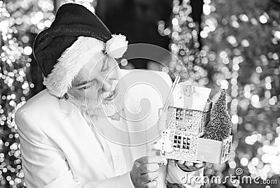 Wishing a happy New Year. bearded man hold house and snowman toy. christmas composition. senior businessman in santa Stock Photo