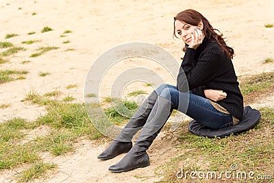 Wistful young woman sitting outdoors alone Stock Photo