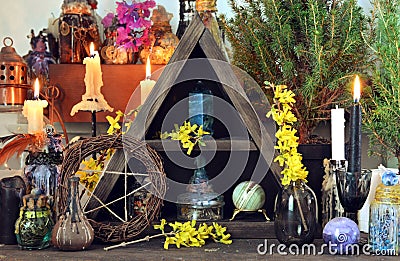 Witch altar with pentagram, spring flowers, black candles Stock Photo