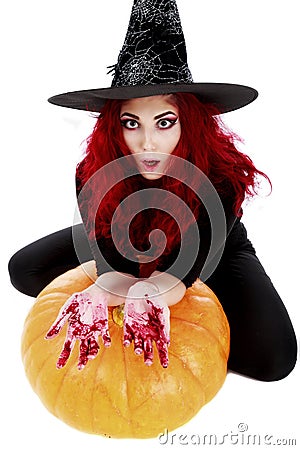 Witch with bloodstained hands with a hatchet in hand sits on a p Stock Photo