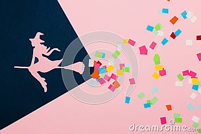 a witch on a broom in flight, a witch on the dark part of the background, on the pink part a magic colorful trace of the broom Stock Photo