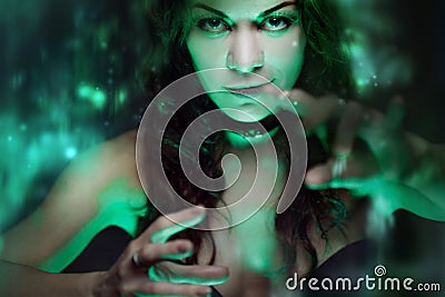 Witch creates magic. Beautiful and woman with a mystical light Stock Photo