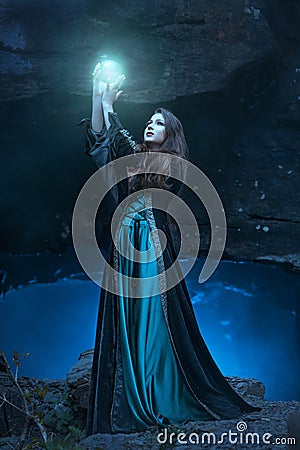 The witch with magic ball in her hands causes a spirits Stock Photo