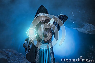 The witch with magic ball in her hands causes a spirits Stock Photo