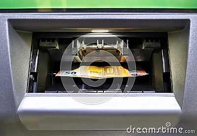 Withdrawing euro money from an ATM machine Stock Photo