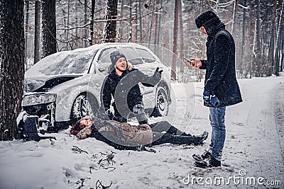 Witness of the accident helps the injured couple to contact the rescue service. Stock Photo