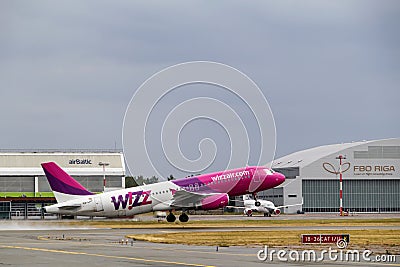 A Wizzair airliner takes off from the runway. Departure of the plane from the airport. Riga International Airport, Marupe, Latvia Editorial Stock Photo