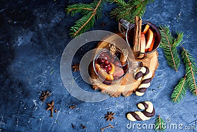Wo glasses of hot red mulled wine decorated with orange, clove, cinnamon and anise. Christmas lights on background. Rustic decor, Stock Photo