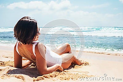 Woamn takes a sun bath on tropical beach Stock Photo