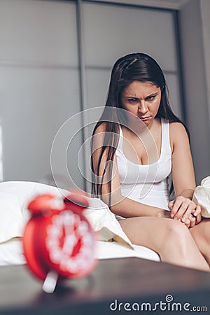 The woken dissatisfied girl sits on a bed Stock Photo