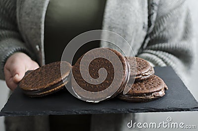 Closeup of chocolate biscuts on the slate board.Woman holding tray with chocolate cookies Stock Photo