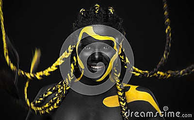 Woman on abstract poster with gold face art. Yellow and black colors of body paint. Young girl with bodypaint. An Stock Photo