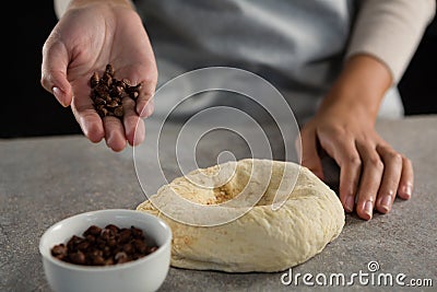 Woman adding chocolate chips into the dough Stock Photo