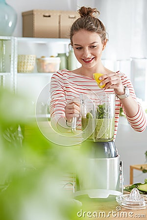 Woman adding lemon juice Stock Photo