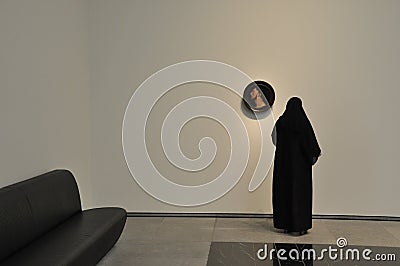 Woman admiring round shaped classic European painting in Louvre Abu Dhabi Editorial Stock Photo