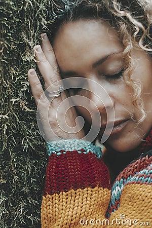 Woman against a green tree trunk covered with musk and closed eyes. Daydreaming and love nature. People female in outdoor leisure Stock Photo