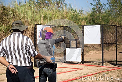 Woman aiming pistol in shooting range for competition Editorial Stock Photo