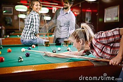 Woman aiming on pool ball while playing billiard Stock Photo