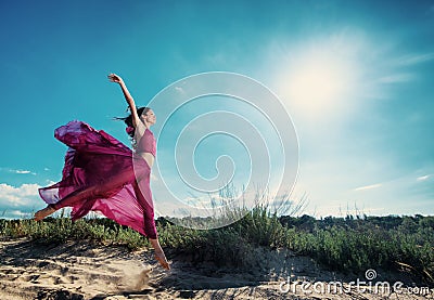 Woman in airy dress running on the beach Stock Photo