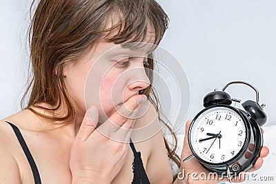Woman with alarm clock comes late to work because she oversleep Stock Photo