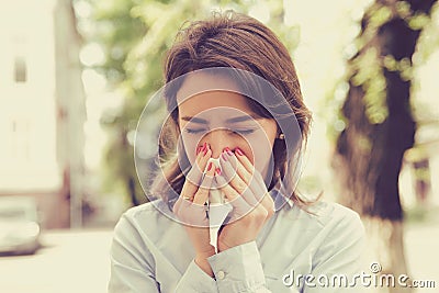 Woman with allergy symptoms blowing nose Stock Photo