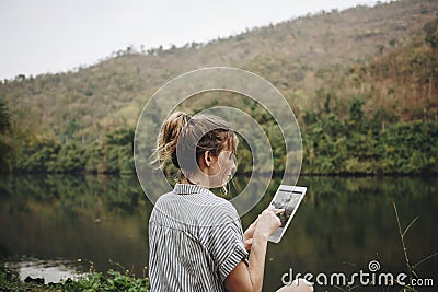 Woman alone in nature using a digital tablet internet connection and travel concept Stock Photo