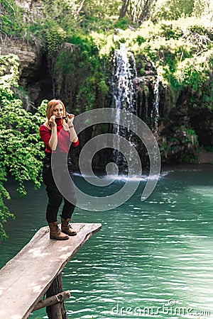 Woman alone sitting, motorcyclists travelers. travel nature Forests, mountains, beautiful waterfall on background. summer day. Stock Photo