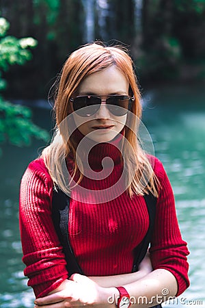 Woman alone sitting, motorcyclists travelers. travel nature Forests, mountains, beautiful waterfall on background. summer day. Stock Photo