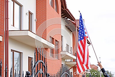 Woman with American flag near apartment building Stock Photo