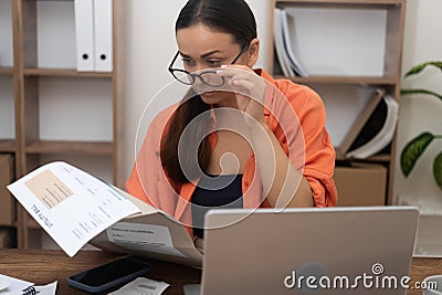 woman anxious lookin to utility bill, concerned about mortgage payment and mounting debt at home. Stock Photo