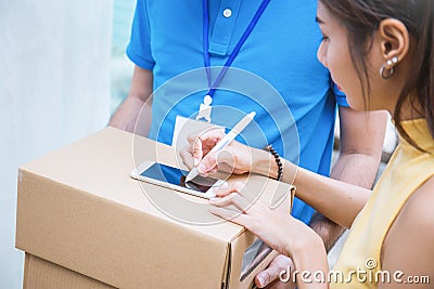 Woman appending receive sign signature after accepting a delivery of boxes Stock Photo