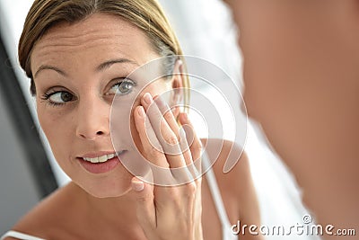 Woman applying daily cream on her face Stock Photo