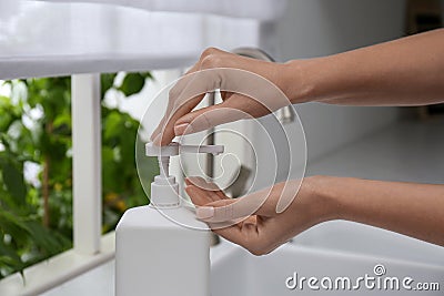 Woman applying hand sanitizer indoors, closeup. Personal hygiene during COVID-19 pandemic Stock Photo