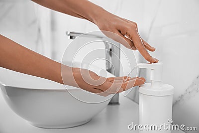 Woman applying hand sanitizer indoors, closeup. Personal hygiene during COVID-19 pandemic Stock Photo