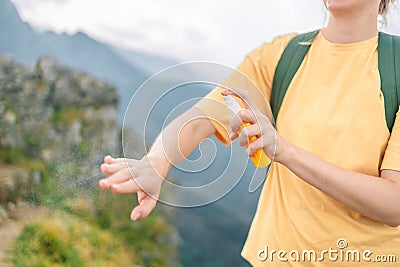 Woman applying insect repellent against mosquito and tick on her hand during hike in nature top mountain. Skin Stock Photo