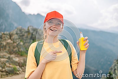 Woman applying insect repellent against mosquito and tick on her hand during hike in nature top mountain. Skin Stock Photo