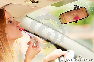 Woman applying makeup while driving her car Stock Photo