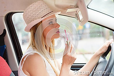 Woman applying makeup while driving her car Stock Photo