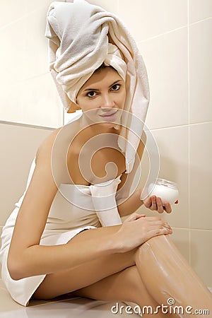 Woman applying moisturizer cream on the legs Stock Photo