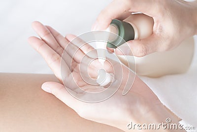 Woman applying moisturizing cream/lotion on hands on white bed, beauty concept Stock Photo