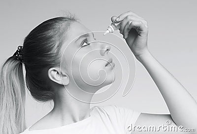 Woman applying ophthalmology eyedropper, glaucoma eye prevention Stock Photo