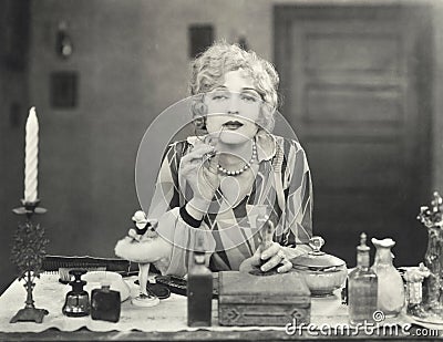 Woman applying perfume to her lips Stock Photo