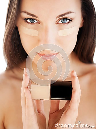 Woman applying skin foundation Stock Photo