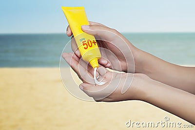 Woman applying sunscreen on her hand with sea background. SPF sunblock protection concept. Travel vacation Stock Photo