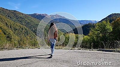 Woman approaches cliff somewhere in mountains and spreading his arms out to side. Beautiful young woman approaches cliff somewhere in mountains in summer at stock footage Woman approaches cliff somewhere in mountains and spreading his arms out to side. Beautiful young woman approaches cliff somewhere in mountains in summer at stock footage