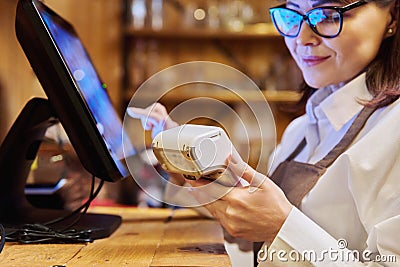 Woman worker manager of restaurant holding wireless banuov payment terminal Stock Photo