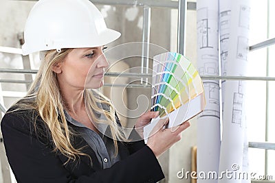 Woman architect or construction interior designer with color swatches palette chooses the color for the house walls inside a Stock Photo