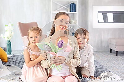 Woman with artificial flowers received from her children for Mother's Day at home Stock Photo